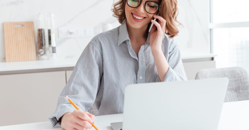 portrait-beautiful-smiling-woman-glasses-taking-notes-while-speaking-mobile-phone-indoors-scaled.jpg